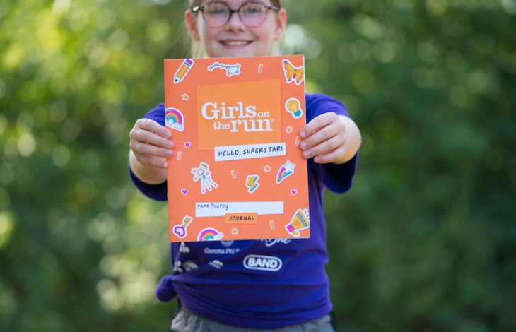Girl holding orange Hello, Superstar book
